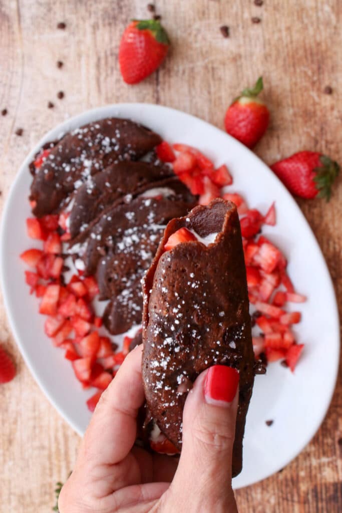 woman's hand holding a chocolate taco