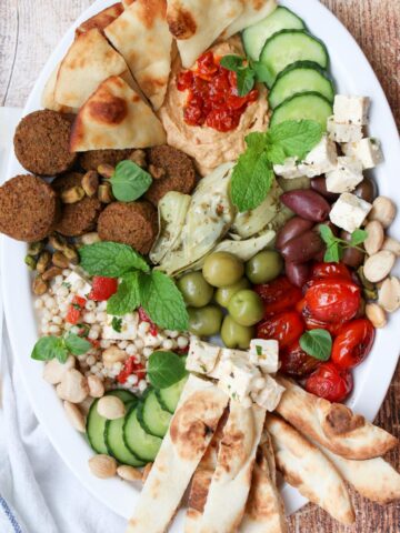 Platter of assorted Mediterranean foods on a large white oval plate
