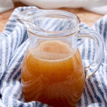 SMALL JAR OF BOURBON BUTTER SAUCE ON A BLUE AND WHITE CLOTH