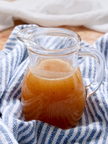 SMALL JAR OF BOURBON BUTTER SAUCE ON A BLUE AND WHITE CLOTH