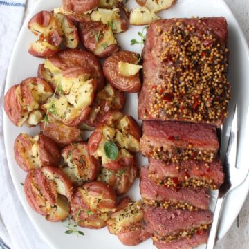 CORNED BEEF BRISKET AND POTATOES ON A WHITE PLATTER