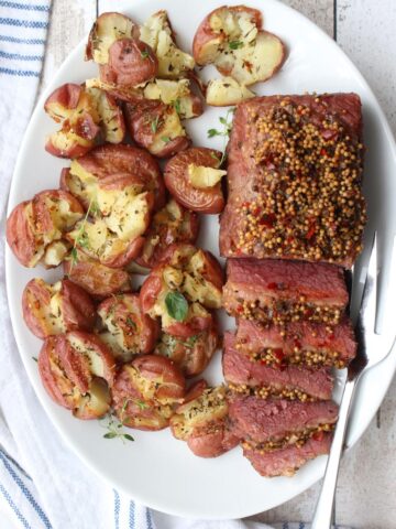 CORNED BEEF BRISKET AND POTATOES ON A WHITE PLATTER