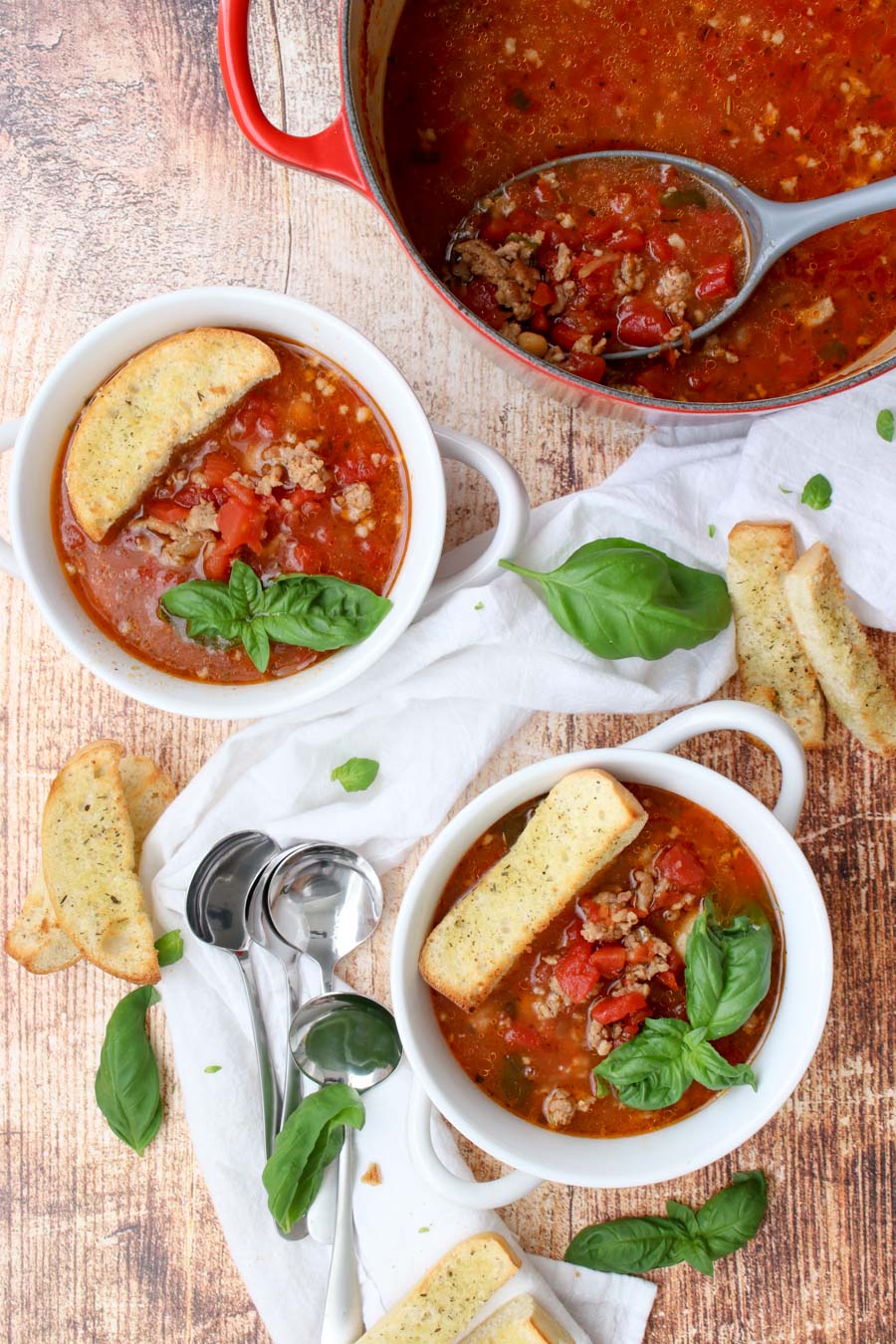 two bowls and one large pot of sausage and bean soup