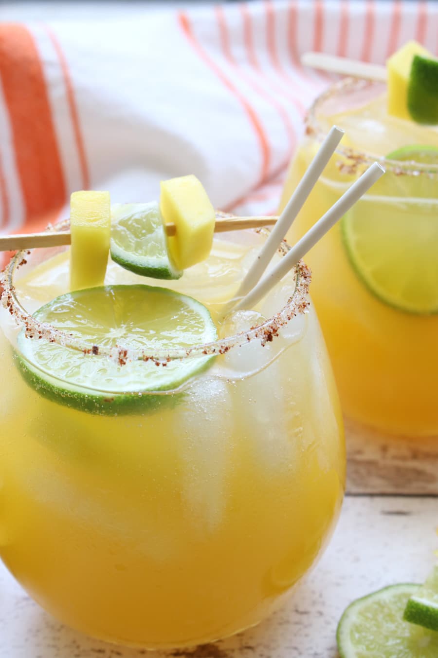 glass of mango margarita with garnish and straws