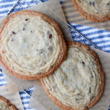 Giant chocolate chip cookies with a glass of milk on the side