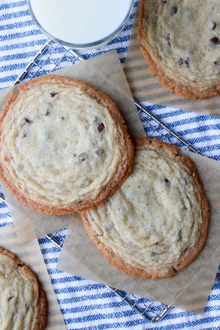 Giant chocolate chip cookies with a glass of milk on the side