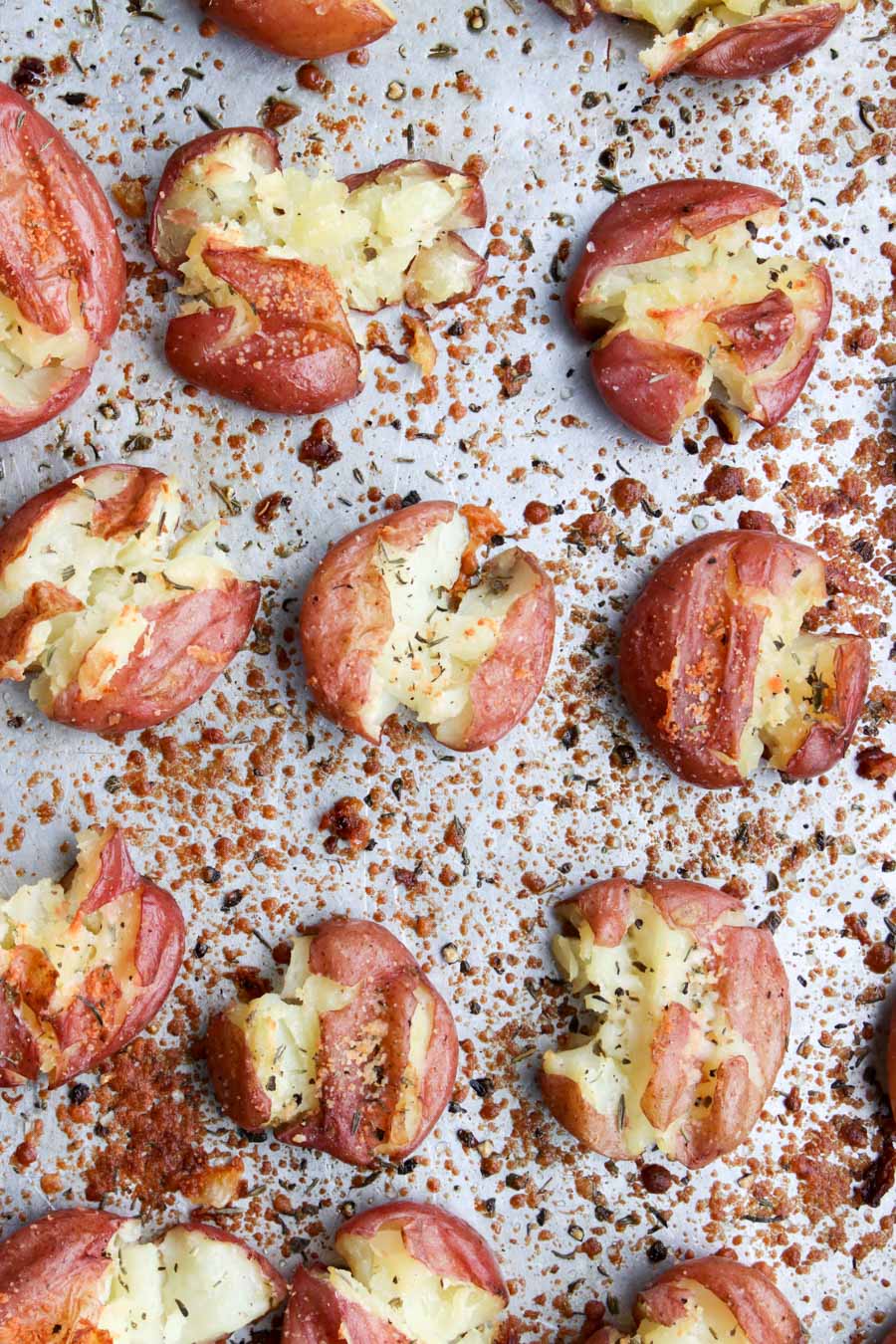 close up photo of smashed potatoes on a cookie sheet