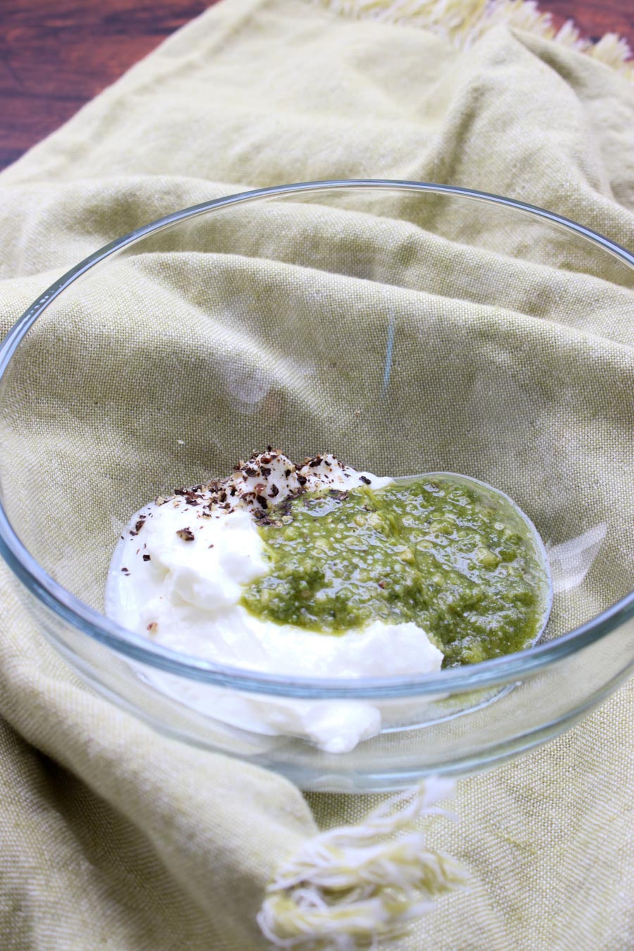 pesto sauce and yogurt in a clear glass bowl