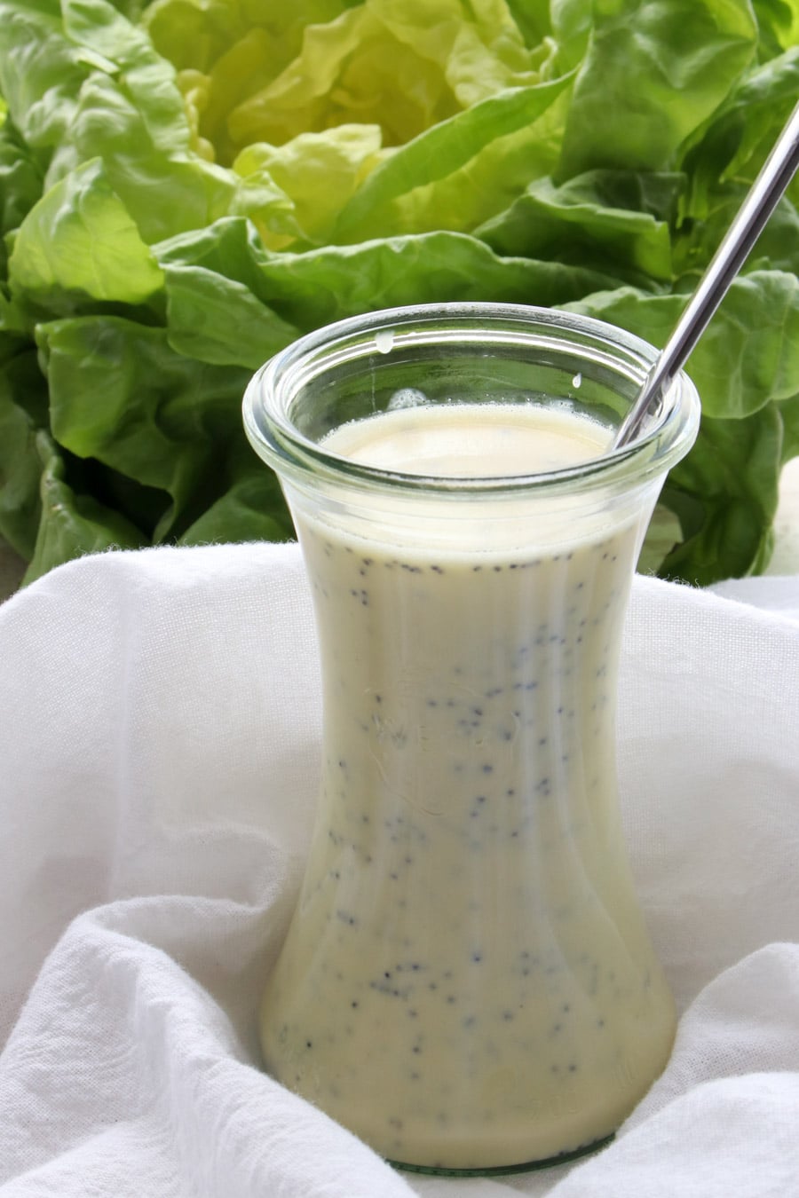 jar of salad dressing with lettuce in background