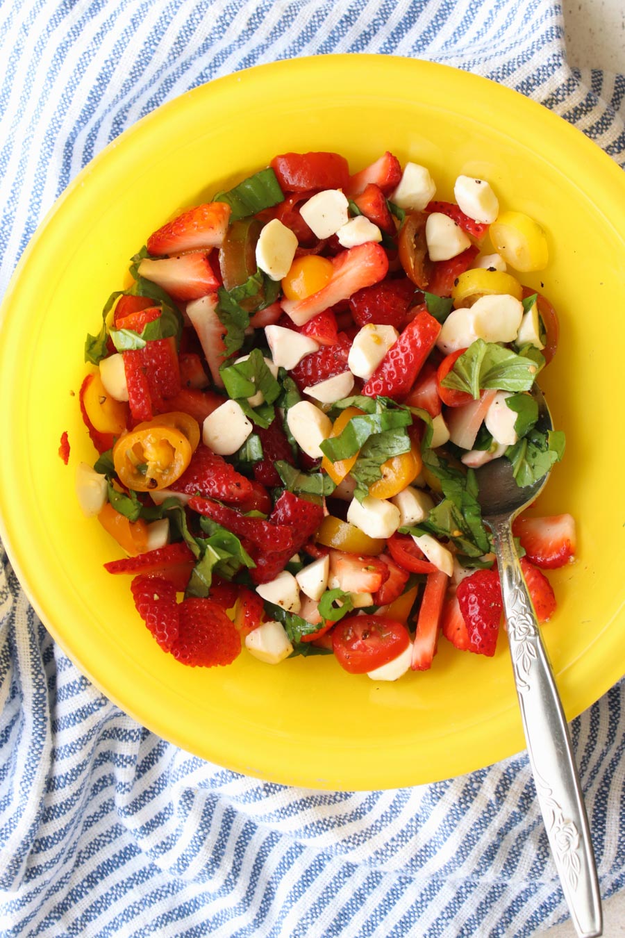 yellow bowl with strawberry cypress salad in it