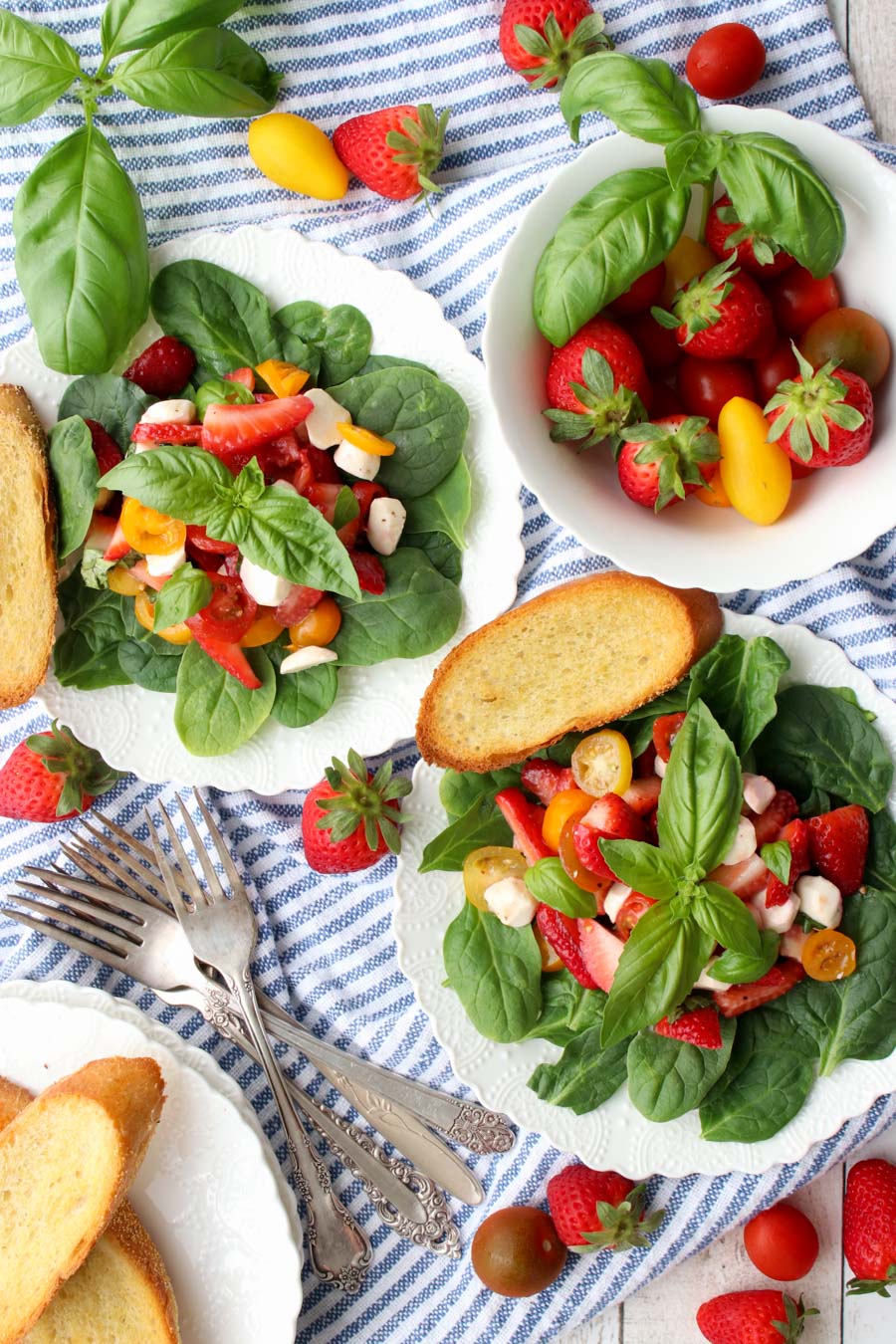 two strawberry cypress salads and a bowl of fresh strawberries