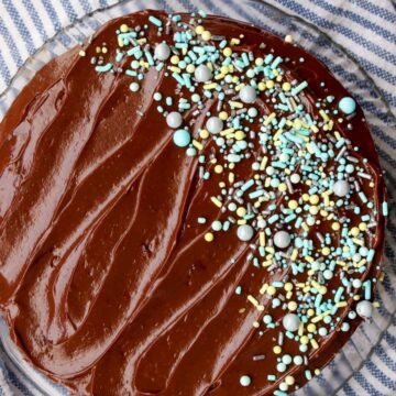 Overhead shot of chocolate frosted cake with blue and green sprinkles