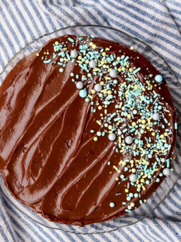 Overhead shot of chocolate frosted cake with blue and green sprinkles