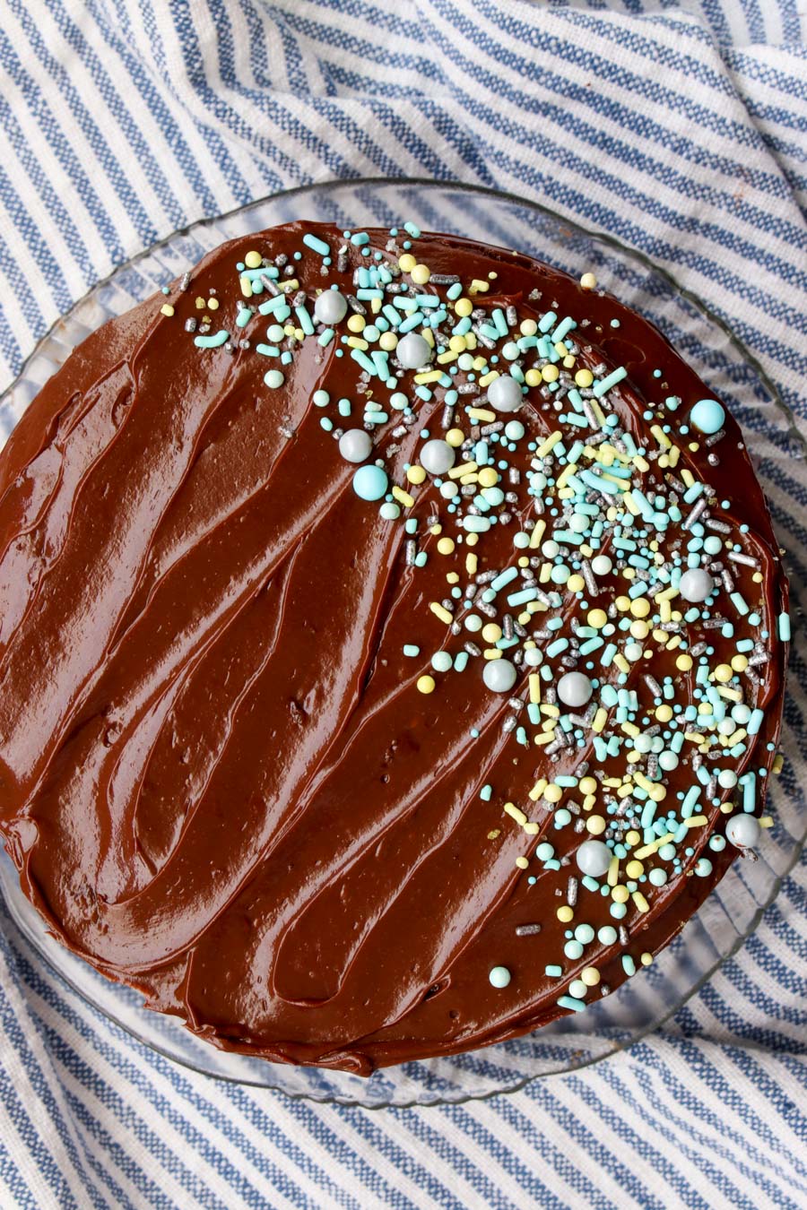 Overhead shot of chocolate frosted cake with blue and green sprinkles