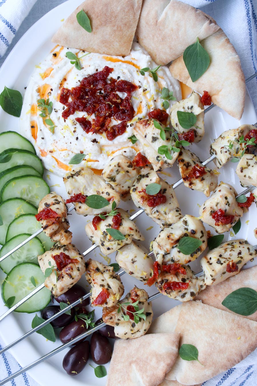 Platter of kabobs and whipped feta with cucumbers and pita