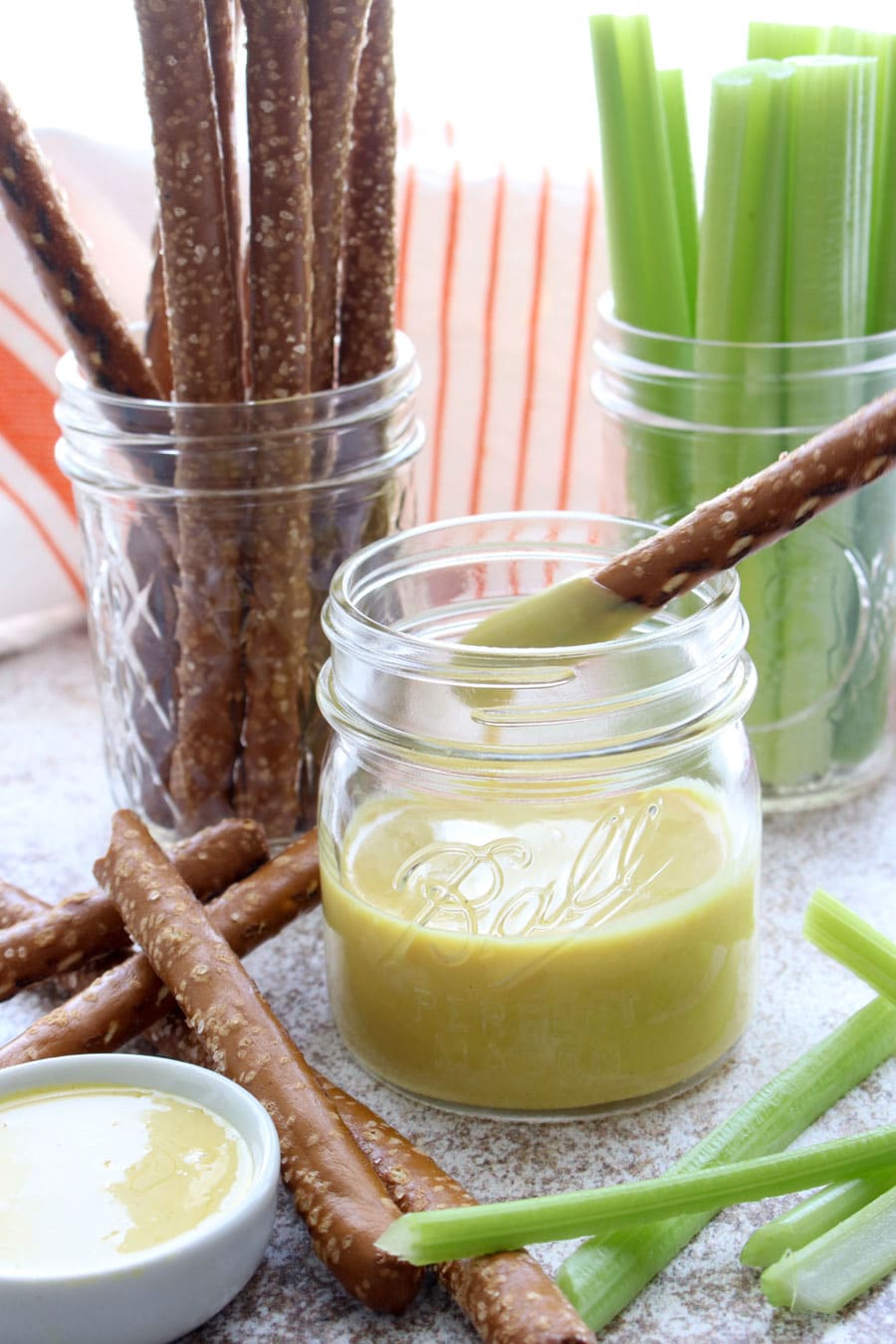 Jar of honey mustard, jar of celery sticks, jar of pretzel sticks