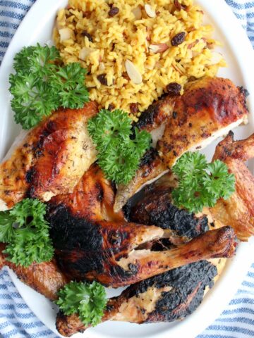 grilled chicken on a platter with yellow rice