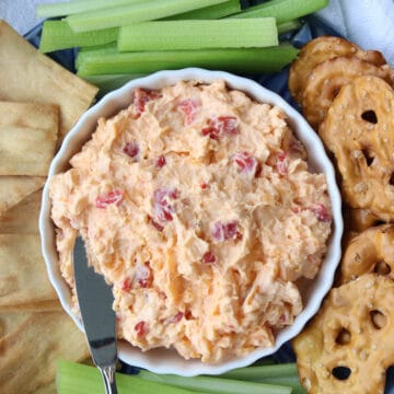 bowl of pimento cheese with crackers and celery sticks