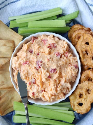 bowl of pimento cheese with crackers and celery sticks