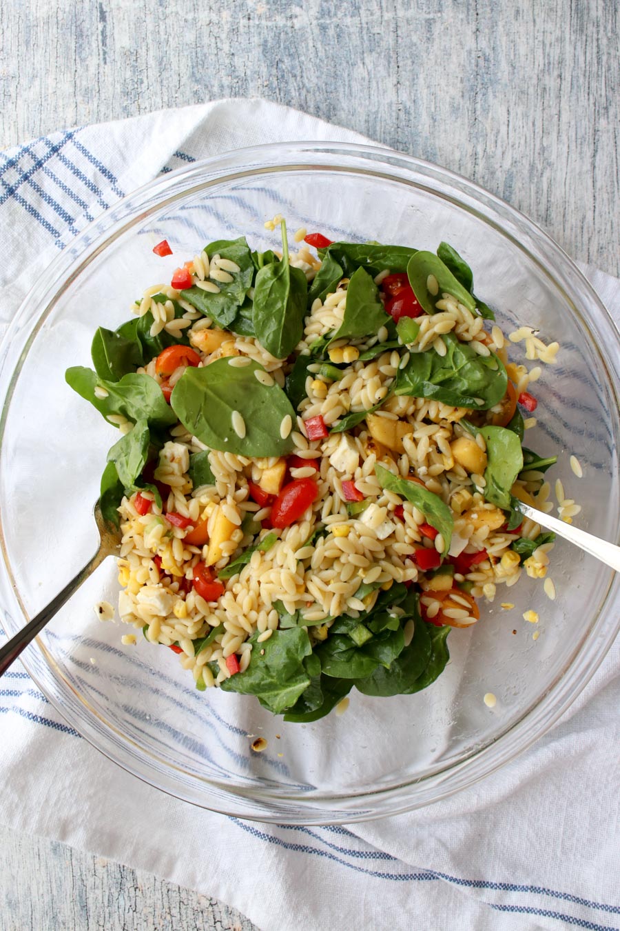 bowl with ingredients mixed for orzo salad