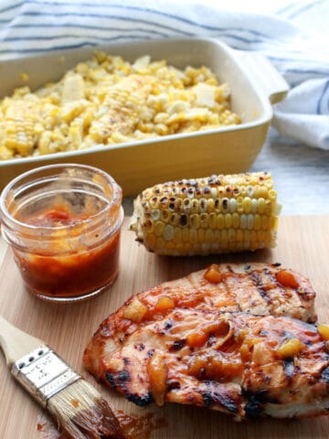 Chicken Breast with Peach BBQ Sauce and a dish of corn in background