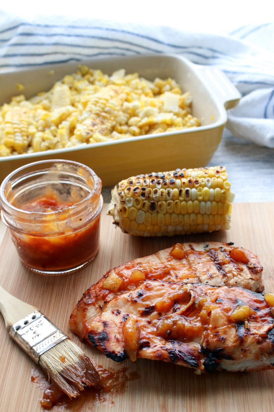 Chicken Breast with Peach BBQ Sauce and a dish of corn in background