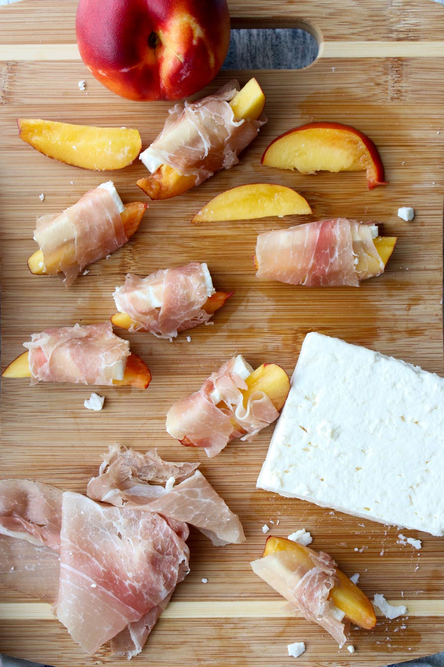 showing how to wrap peaches and feta with prosciutto 