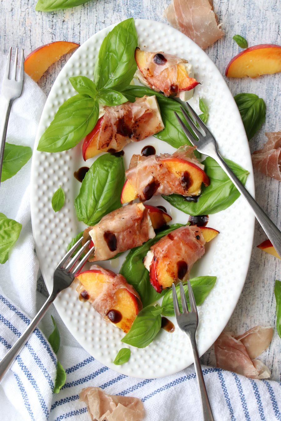 platter of peaches wrapped with prosciutto.