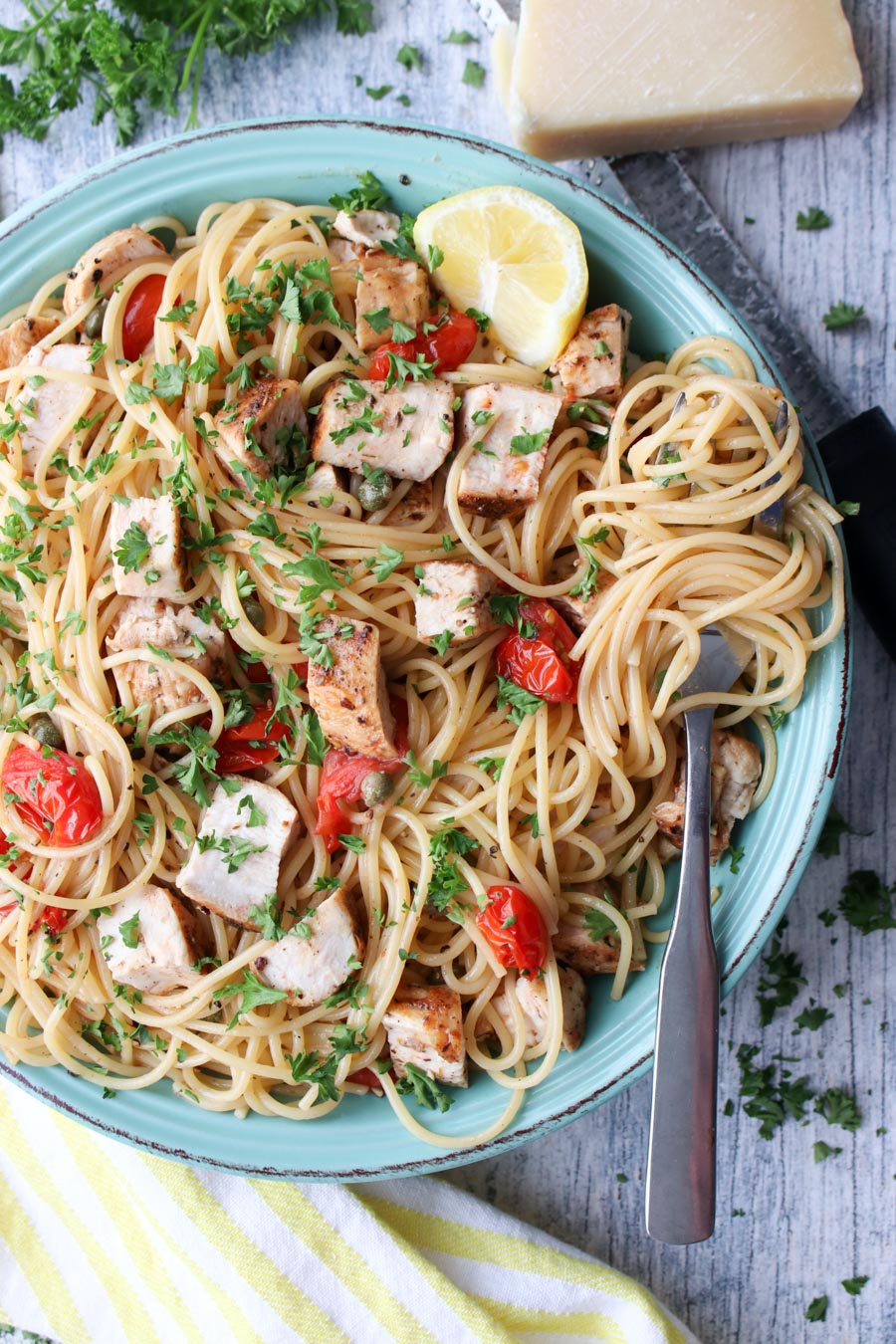 plate of pasta topped with tomatoes and chicken