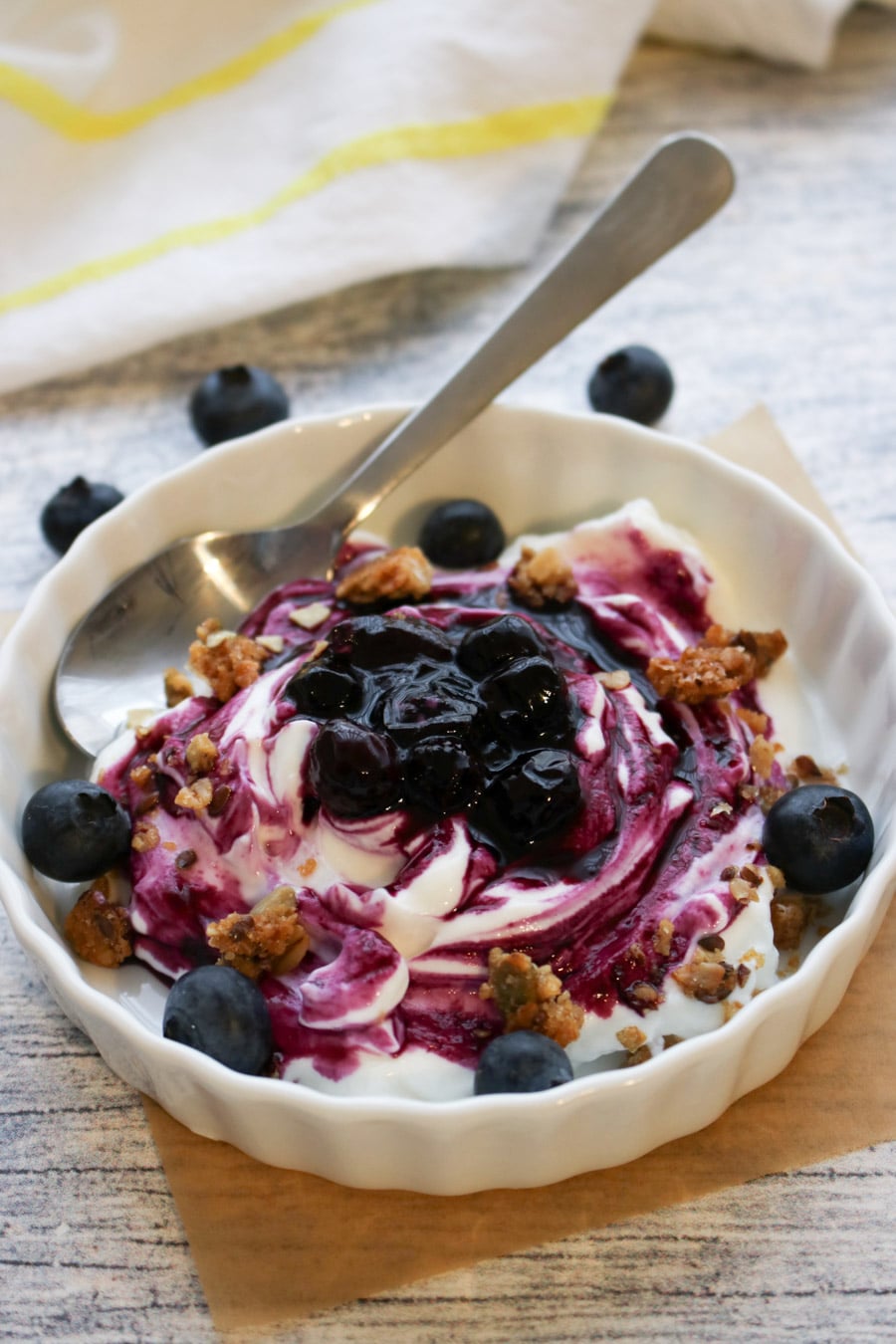 bowl of yogurt covered with blueberry sauce and granola