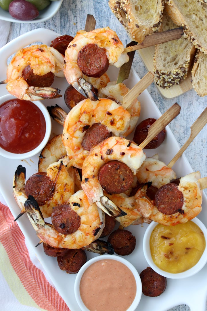 platter of shrimp and chorizo skewers with bread and olives