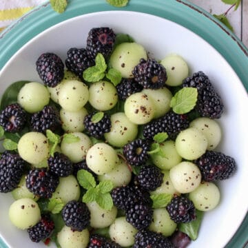 Blackberrys and melon balls in a white dish sprinkled with pepper