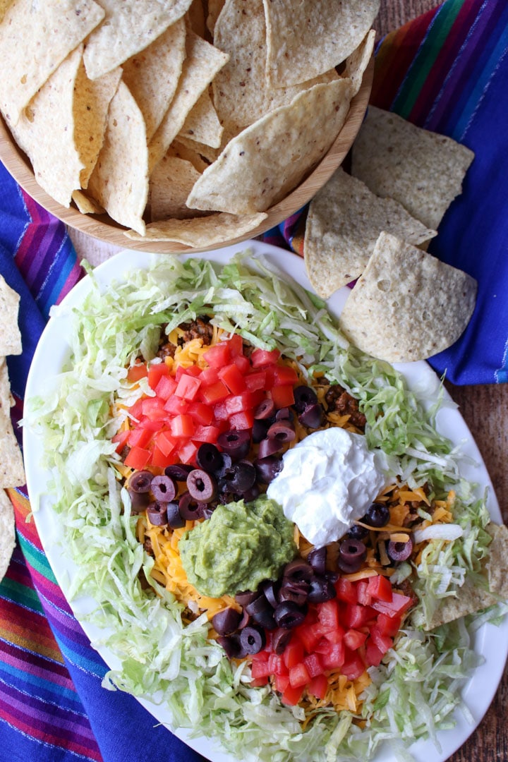 taco dip platter and a bowl of tortilla chips