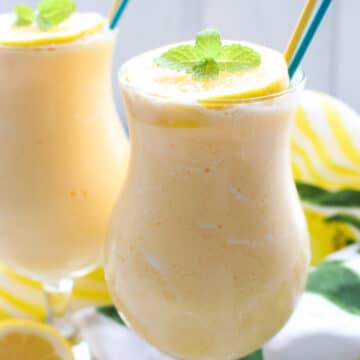 TWO GLASSES OF FROZEN LEMONADE WITH A YELLOW AND BLUE STRAW