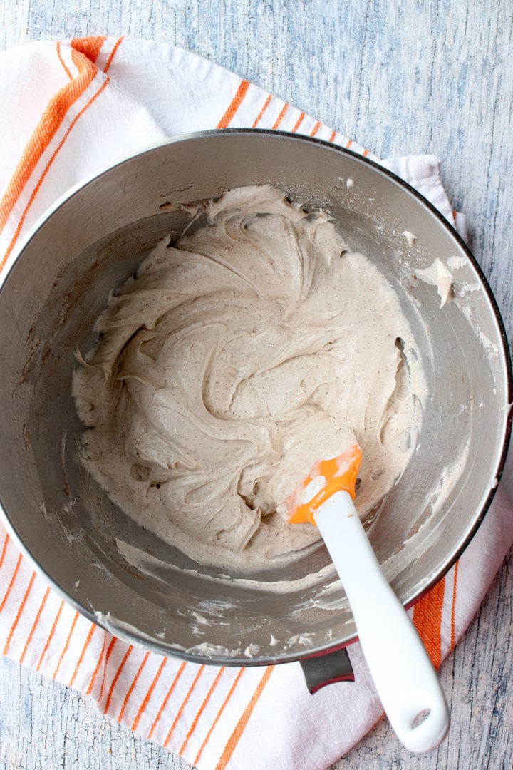 mixer bowl with cream cheese frosting and a spatula