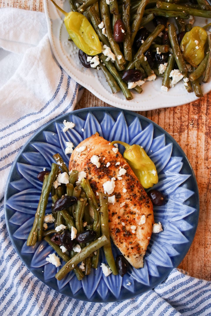 Blue plate with green beans and grilled chicken breast.