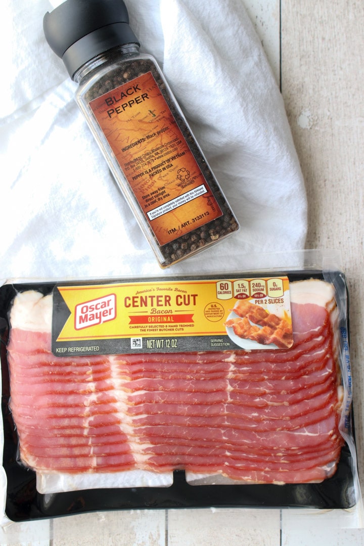 pound of bacon in the package and black pepper mill