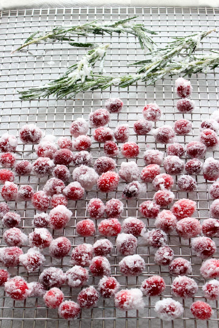 Sugared cranberries and rosemary on a wire rack to cool