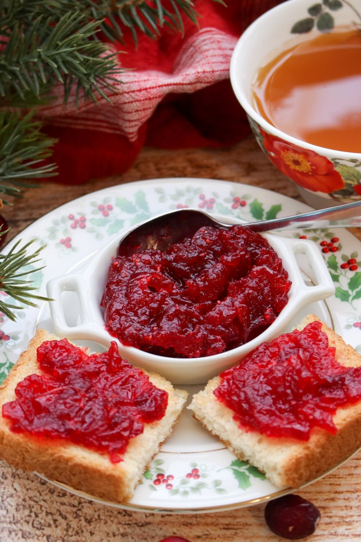 dish of cranberry jam and two small pieces of toast topped with cranberry jam