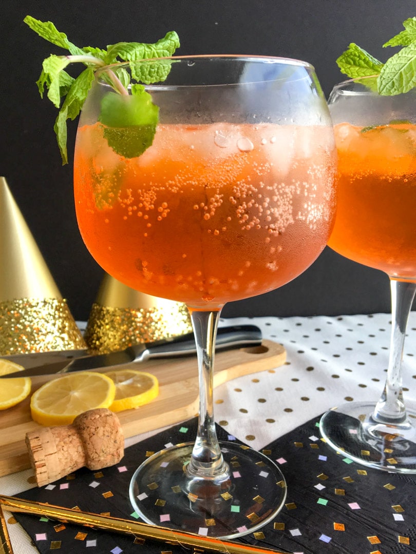 tall glass of orange-colored aperol spritz