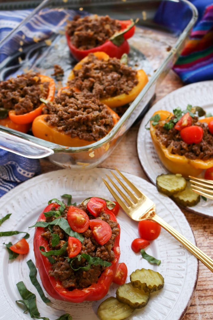 two servings of stuffed peppers with baking dish in background