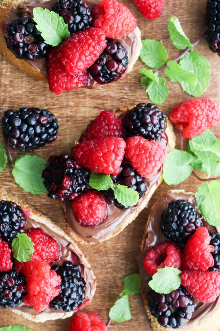 wooden board with berry hazelnut spread bruschetta