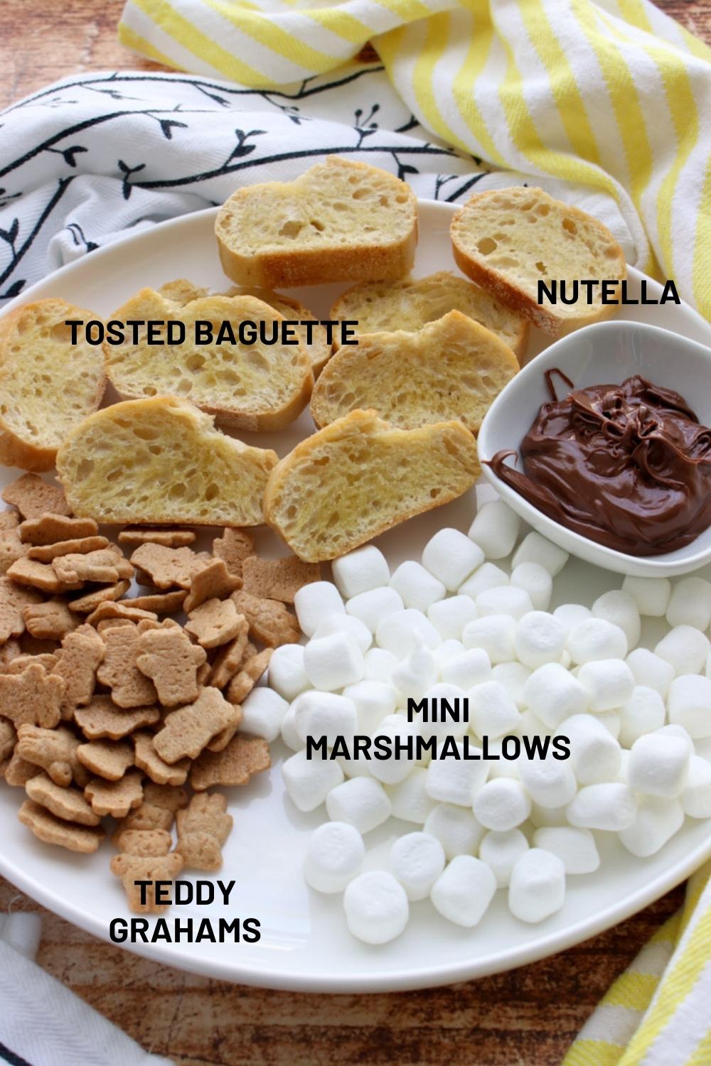 Round wooden tray with ingredients to make Nutella S'more Crostini