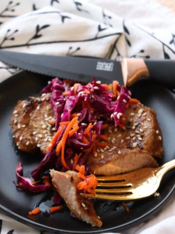 pork chop with carrot cabbage slaw on top