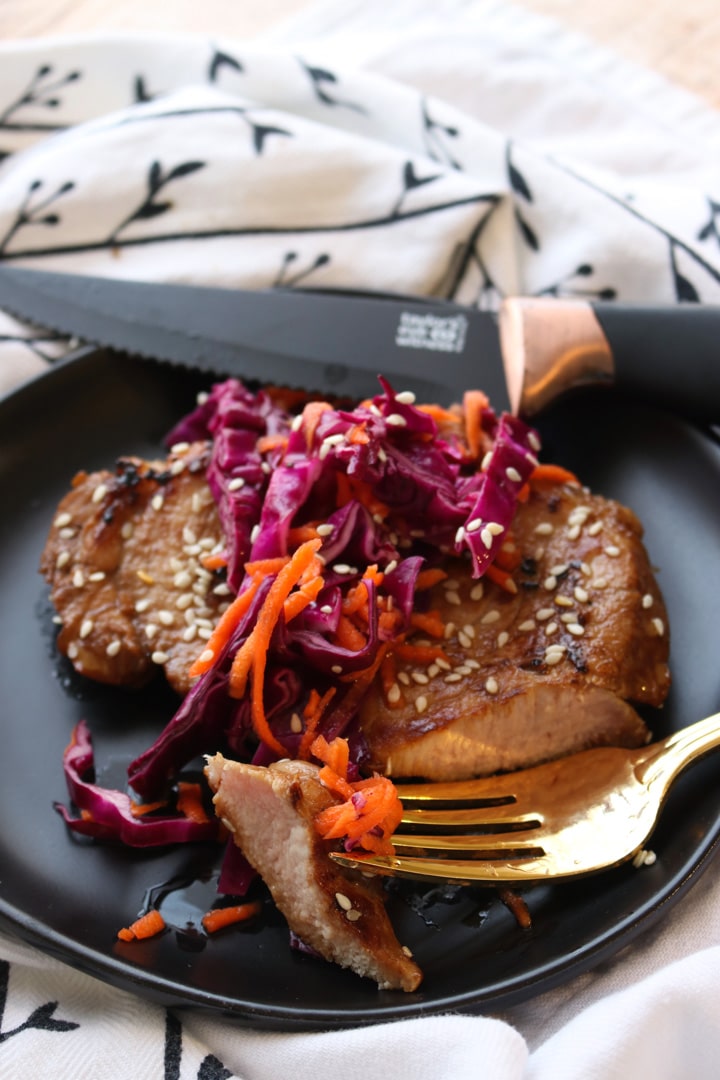 pork chop with carrot cabbage slaw on top