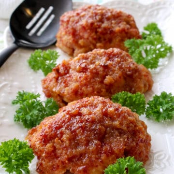 Three ham loaves on a white plate garnished with parsley