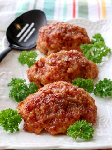 Three ham loaves on a white plate garnished with parsley