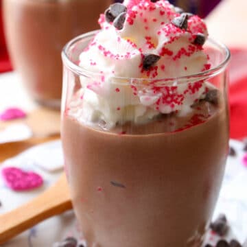 Silken tofu chocolate mousse in a dessert dish topped with whipped cream and sprinkles