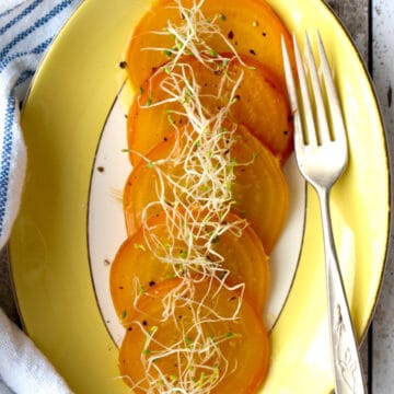 plate of yellow beets with sprouts on top