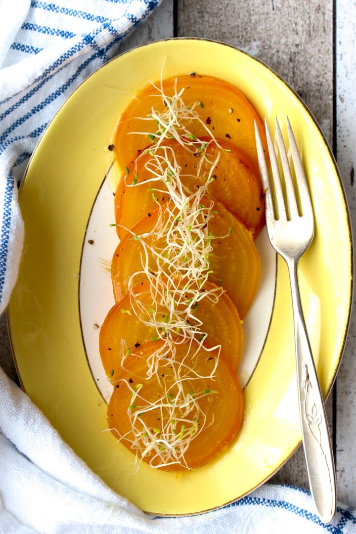 plate of yellow beets with sprouts on top